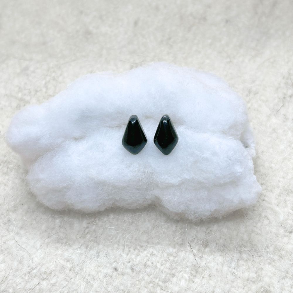 Rhombus-Shaped Black Jade Stud Earrings on a white cloud-shaped object against a beige fabric background