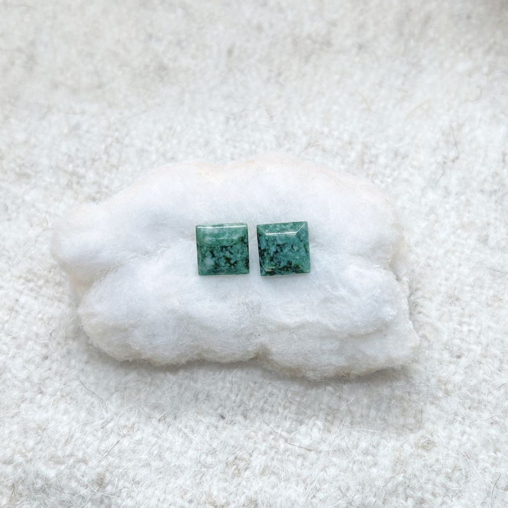 Pair of Square-Shaped Medium Green Jade Stud Earrings on a white fluffy surface