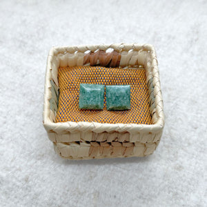 Square-Shaped Medium Green Jade Stud Earrings in a woven basket on a textured white background