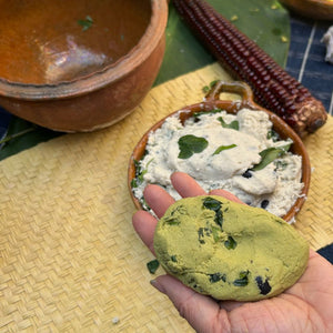 Hand holding a green dough ball for a tamal.