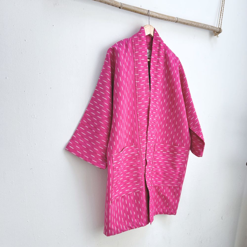 Pink patterned coat on a hanger against a white wall