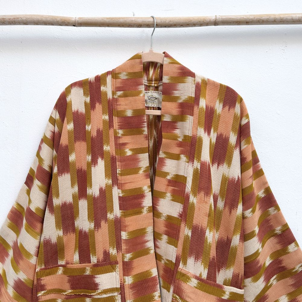 Patterned robe hanging on a rack against a white background