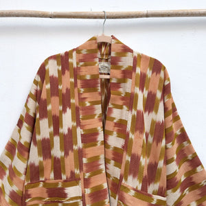 Patterned robe hanging on a rack against a white background