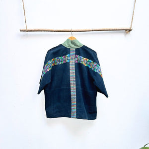 Blue jacket with colorful embroidered details on a white background