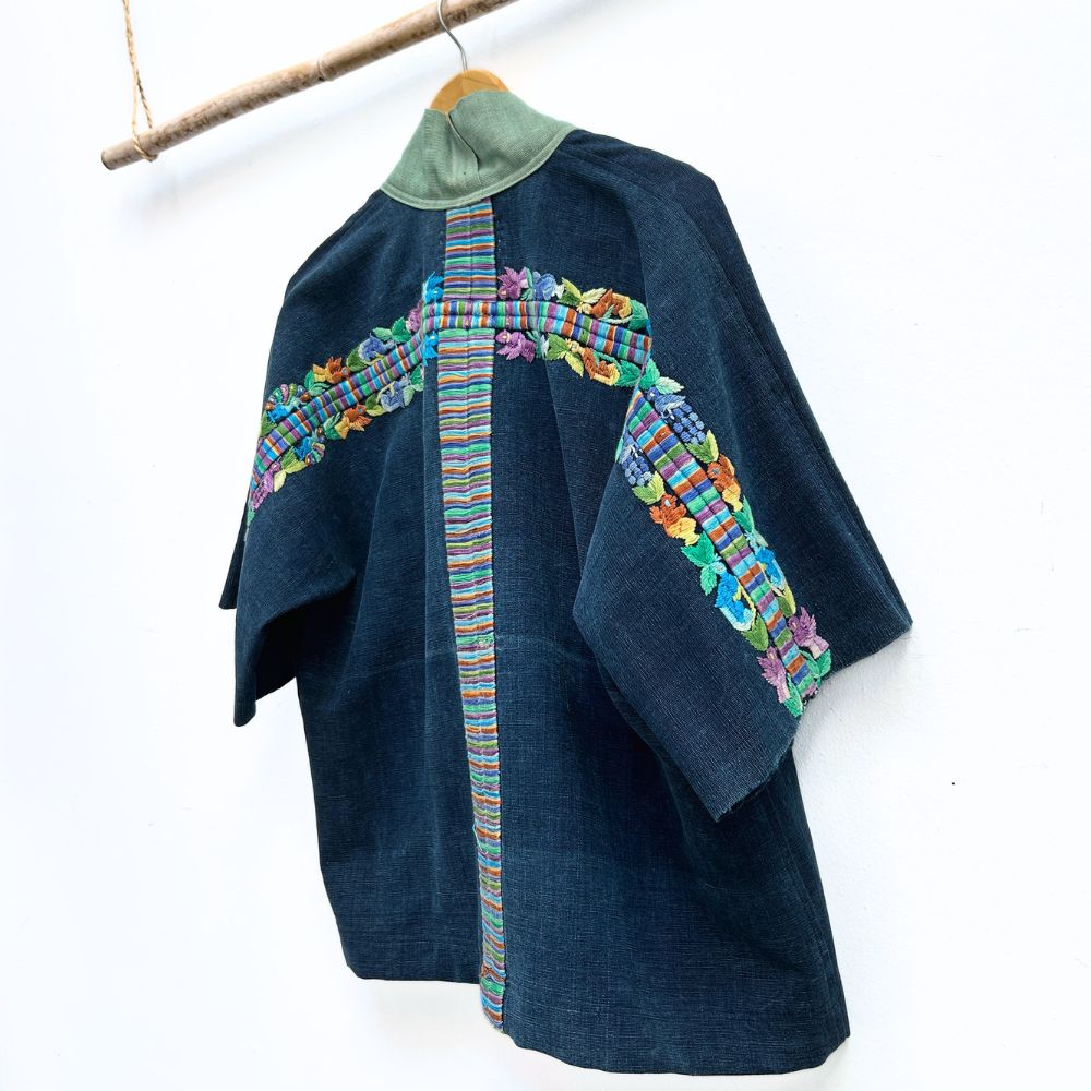 Blue jacket with colorful embroidery on a white background