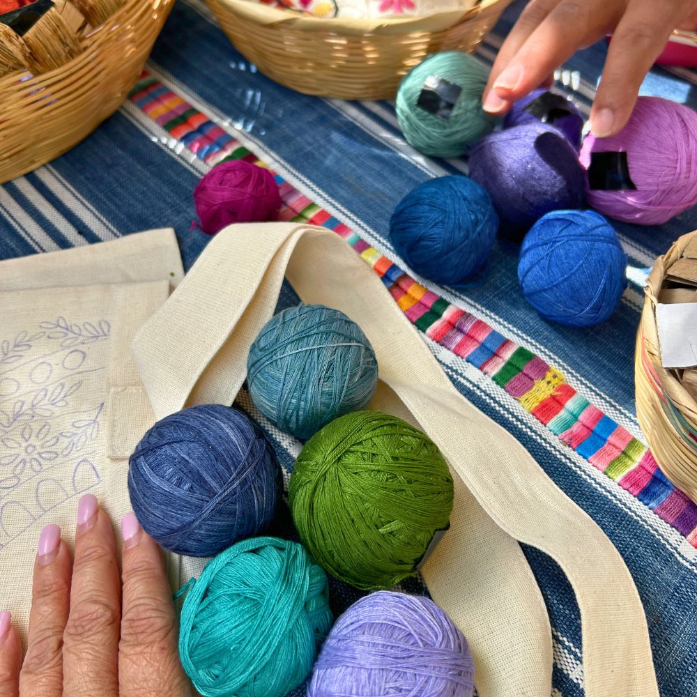 A selection of naturally dyed colorful embroidery threads available for students to choose from while stitching their tote bags.