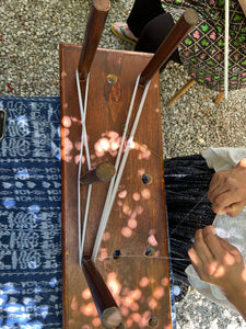 Wooden warping board with thin white threads