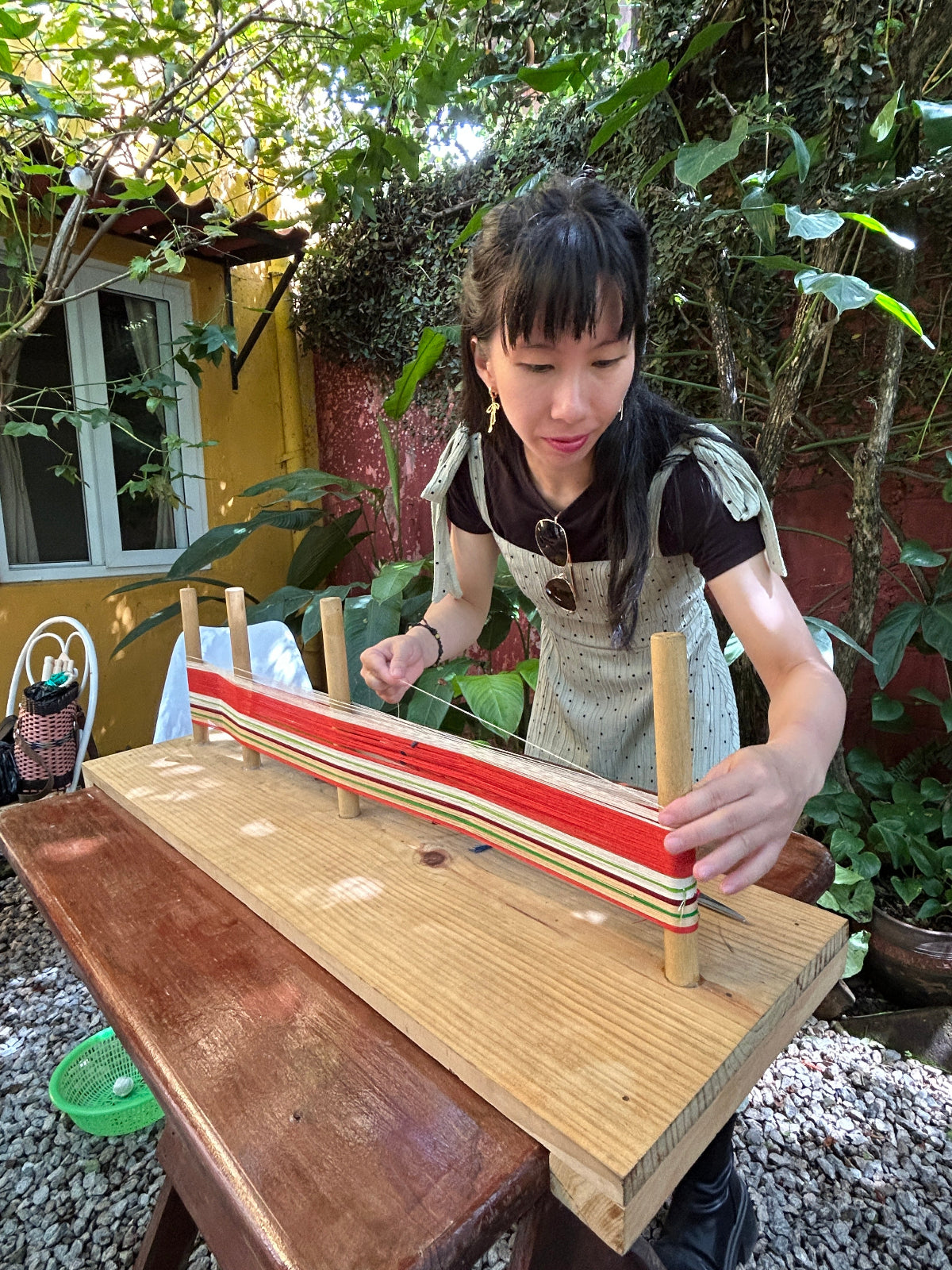 Student warping on a traditional warping board with concentration.
