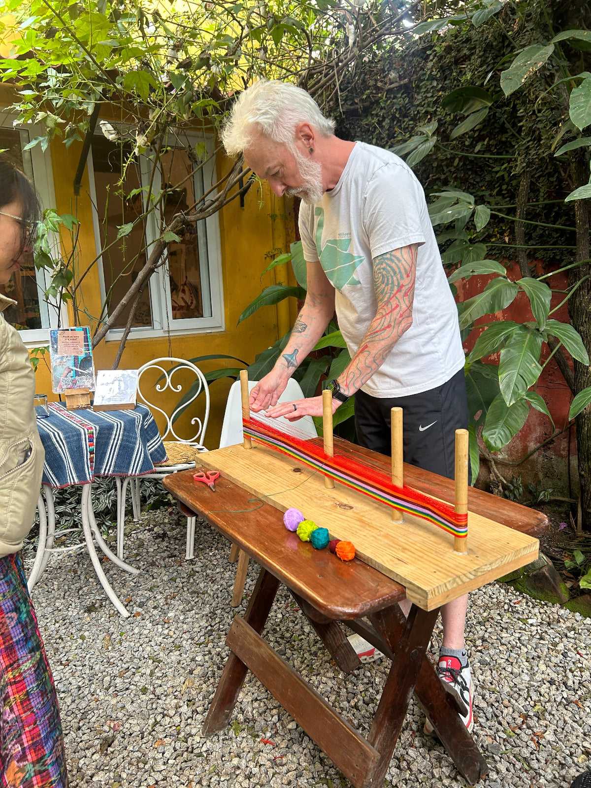 Person working with colorful balls of thread to warp.