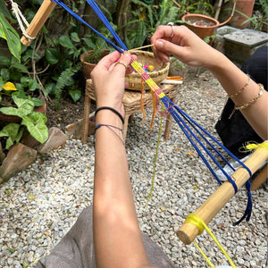 A student putting the final touches on a handmade bracelet she created herself.