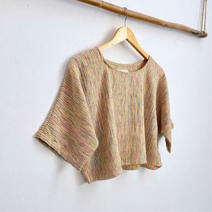 Striped colorful  top on a hanger against a white background
