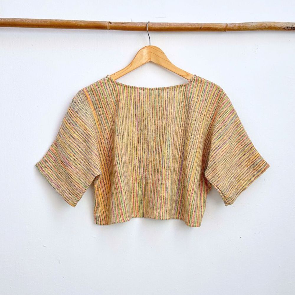 Striped colorful  top on a hanger against a white background