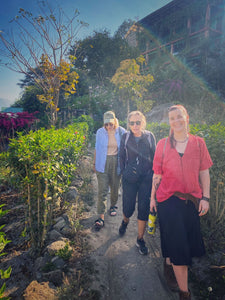 Three people standing on a path surrounded by greenery and plants at Lake Atitlán