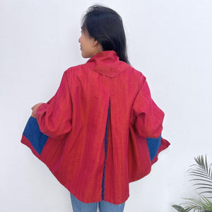 Person wearing a red jacket with blue accents on a white background