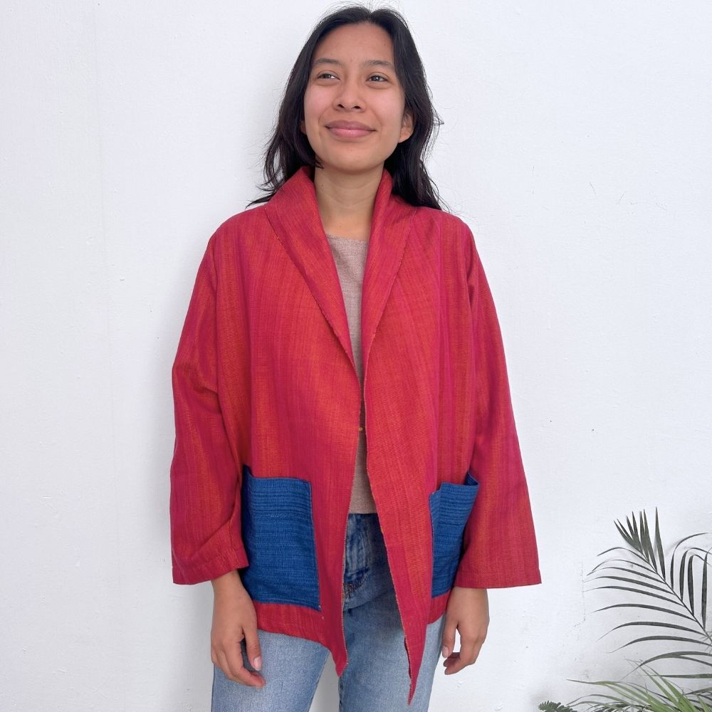 Person wearing a red and blue jacket against a white background