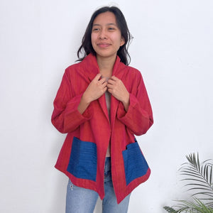Person wearing a red jacket with blue accents against a white background