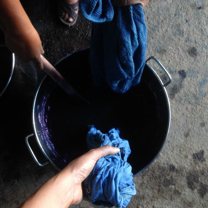 Garments being dipped in an active indigo vat.