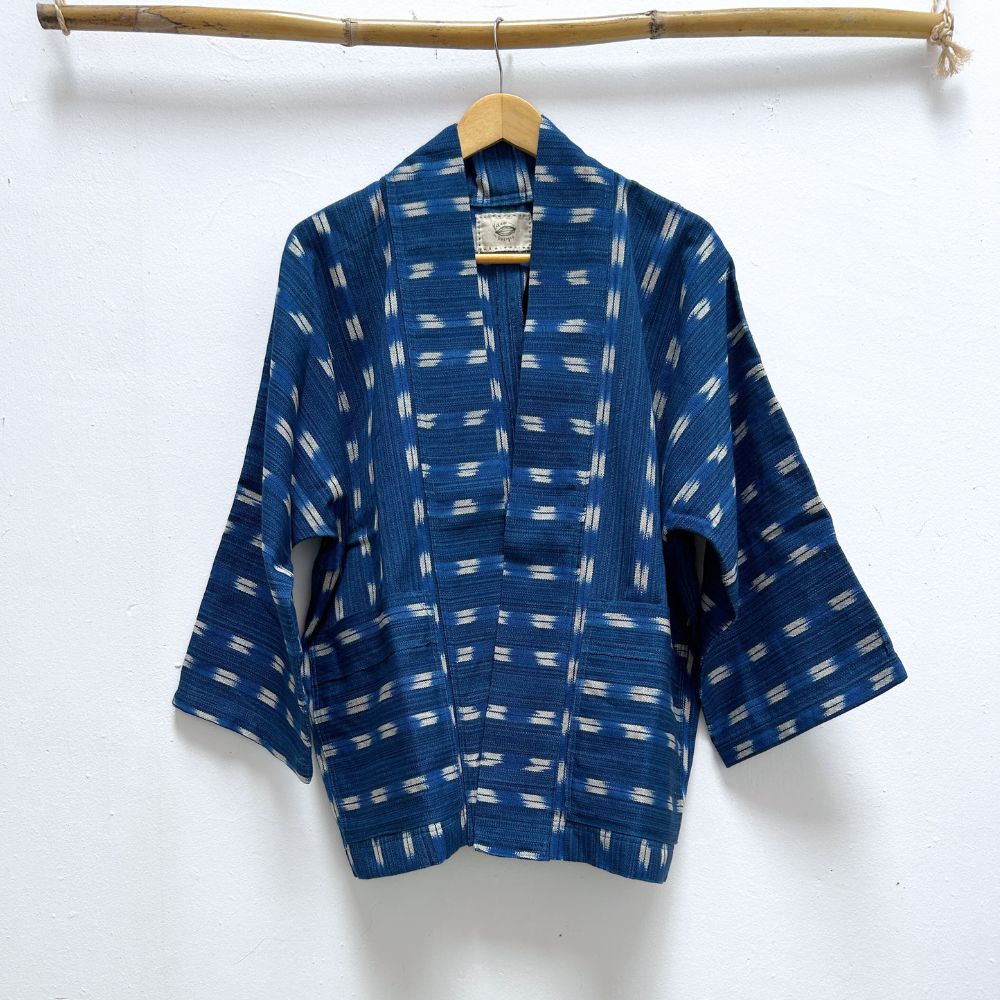 Blue patterned jacket on a hanger against a white background