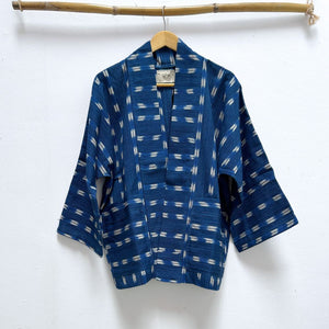 Blue patterned jacket on a hanger against a white background