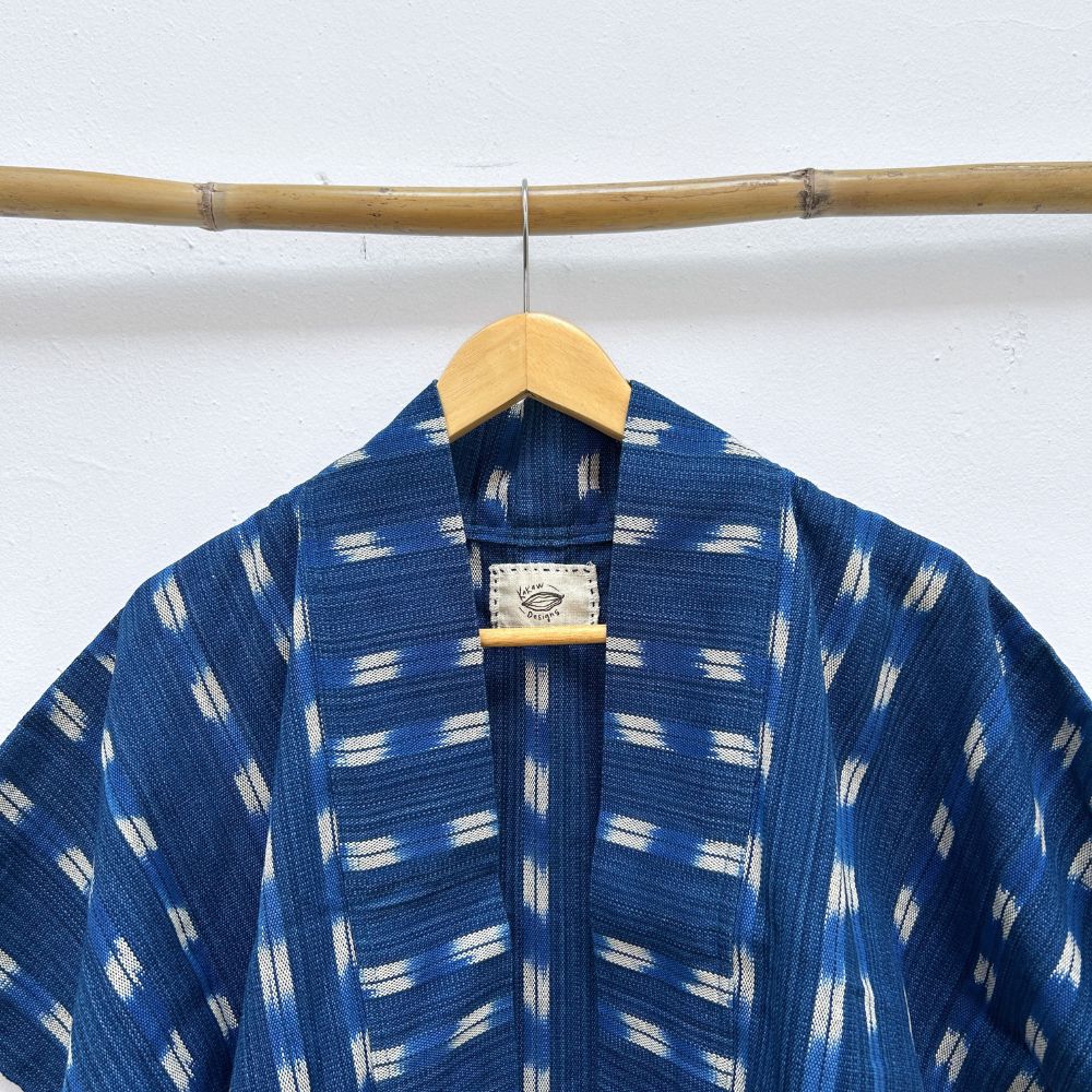 Blue and white patterned jacket on a wooden hanger against a white background