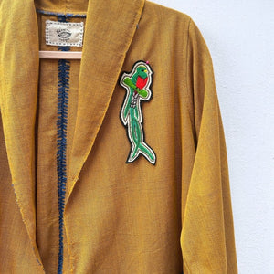 Quetzal embroidered patch on a mustard jacket